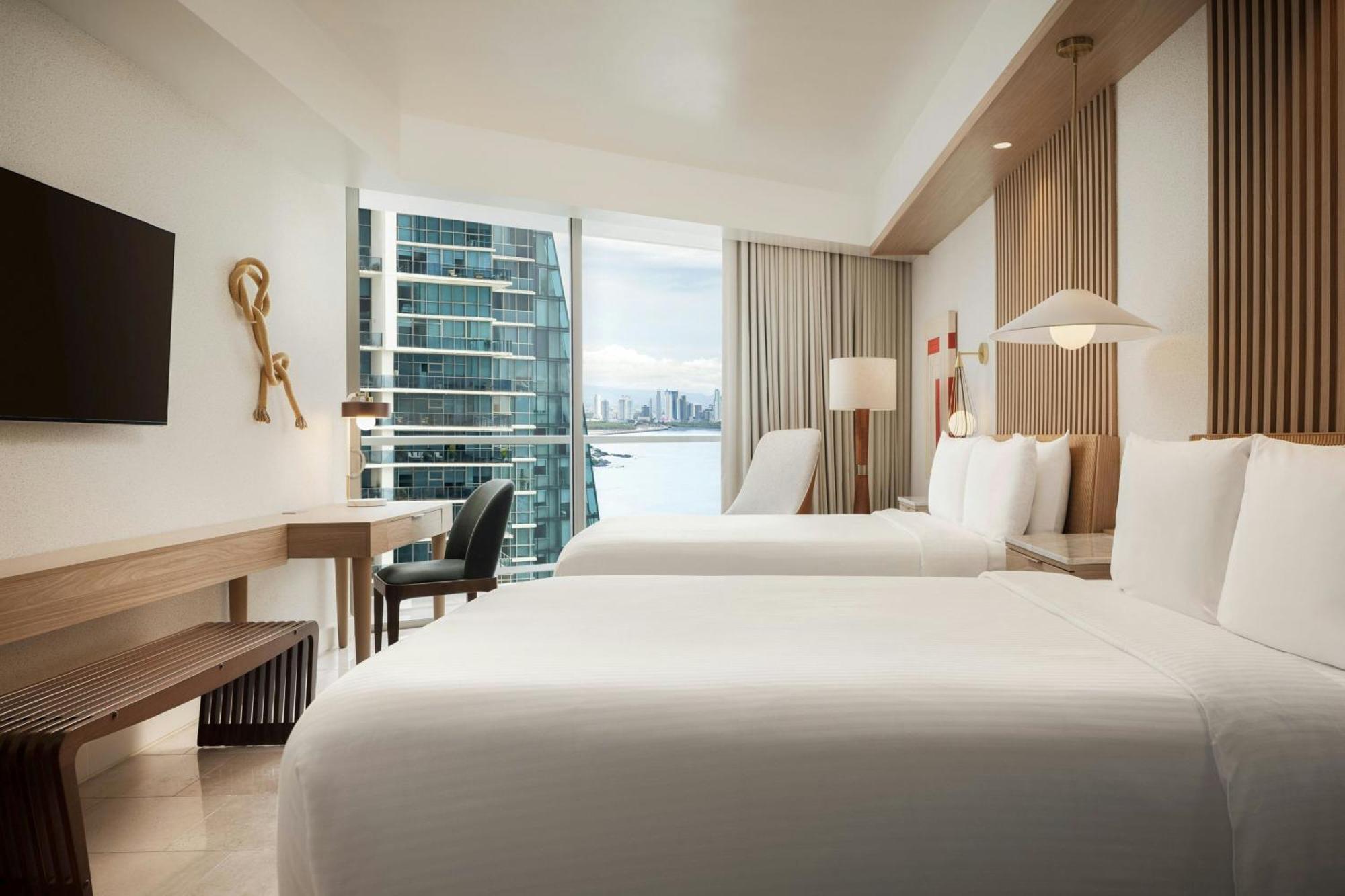Guest room with 2 double beds, balcony and partial ocean view